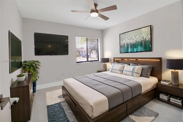 a bedroom with a bed a couch and a flat screen tv