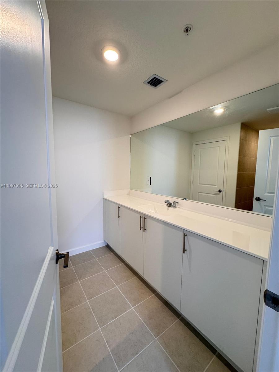 15615 Southwest 280th Street, Unit 10 Homestead, FL 33032 - Photo 18 of 23 a large white bathroom with a double vanity sink a mirror and a shower