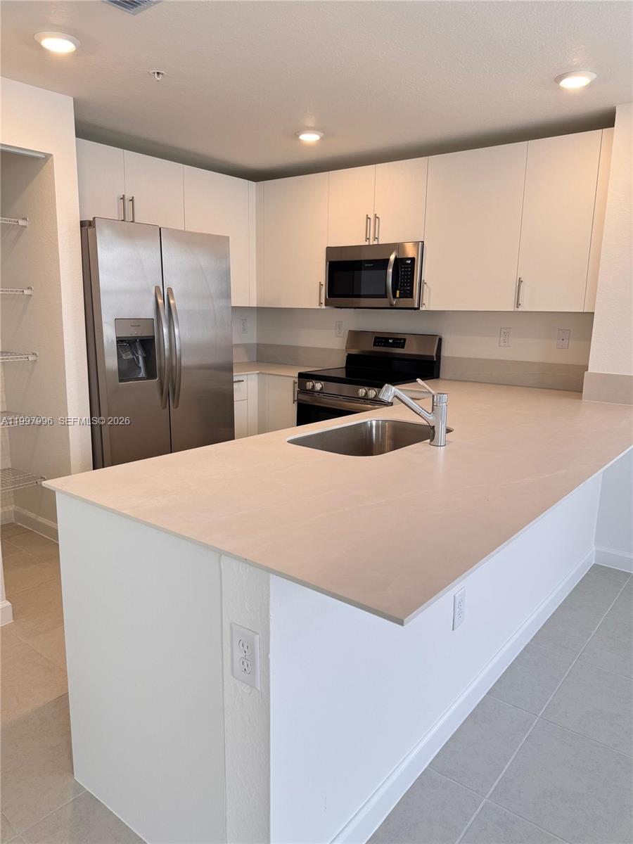 15615 Southwest 280th Street, Unit 10 Homestead, FL 33032 - Photo 4 of 23 a kitchen with stainless steel appliances a refrigerator sink and microwave