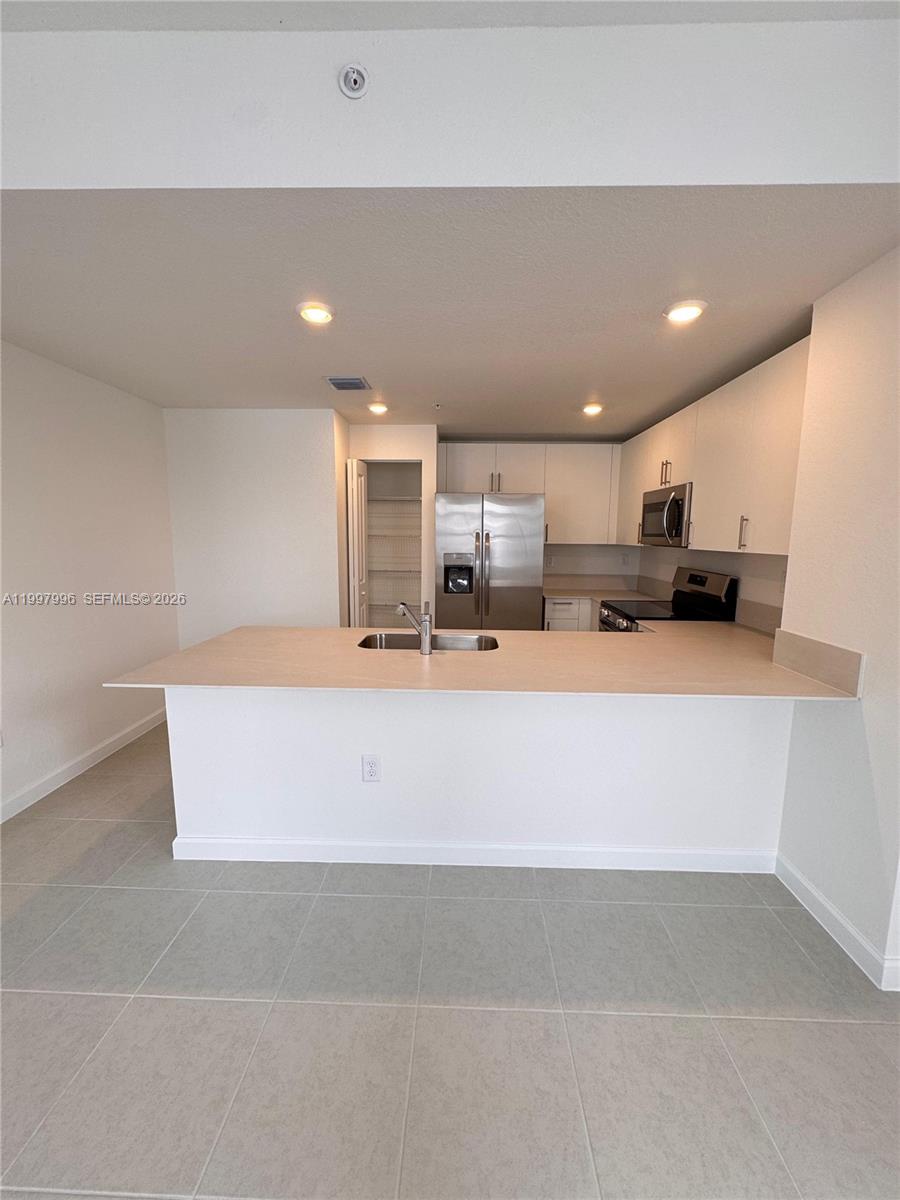 15615 Southwest 280th Street, Unit 10 Homestead, FL 33032 - Photo 6 of 23 a kitchen with kitchen island a sink stainless steel appliances and cabinets