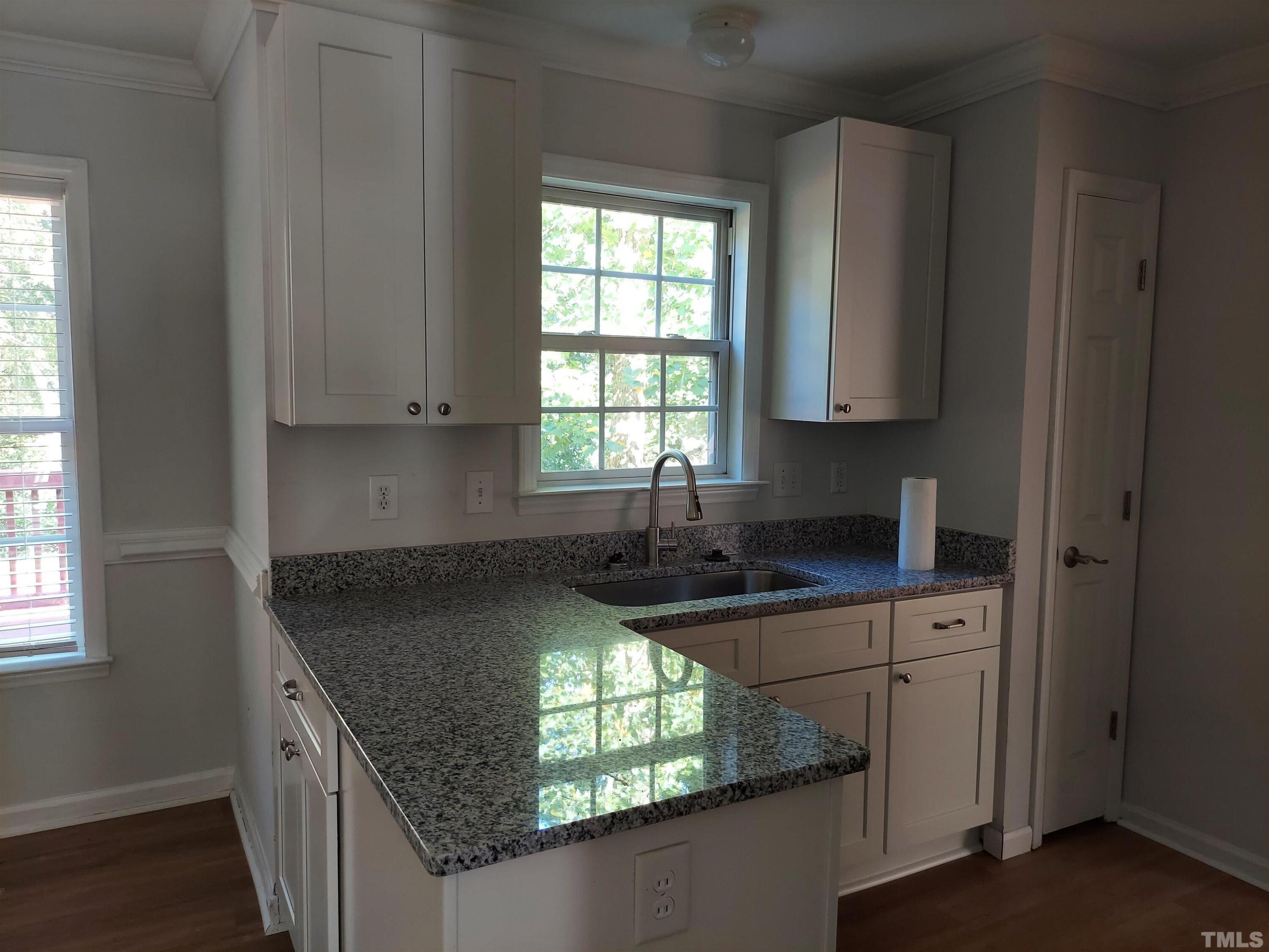 224 Crossfire Road Holly Springs, NC 27540 - Photo 7 of 43 a kitchen with granite countertop a sink window and cabinets
