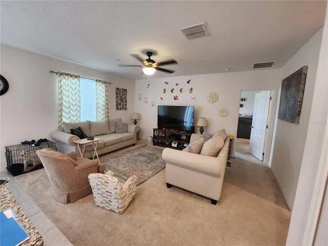 a living room with furniture a fireplace and a window
