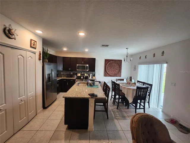 a large kitchen with a table and chairs
