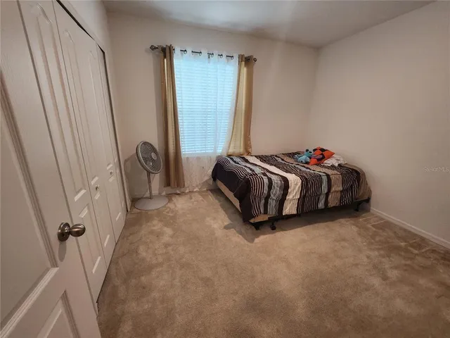 a bed sitting in a bedroom next to a window