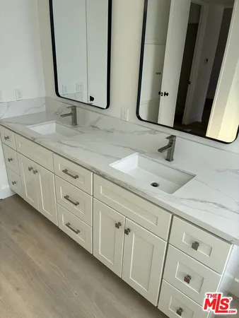 a bathroom with a granite countertop sink a mirror and shower