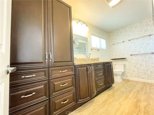 a bathroom with a granite countertop sink and a mirror