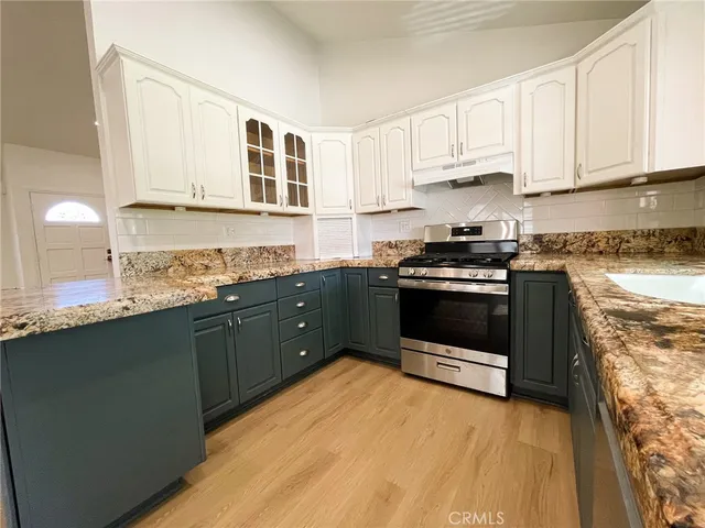 a kitchen with stainless steel appliances granite countertop a stove a sink and a granite counter tops