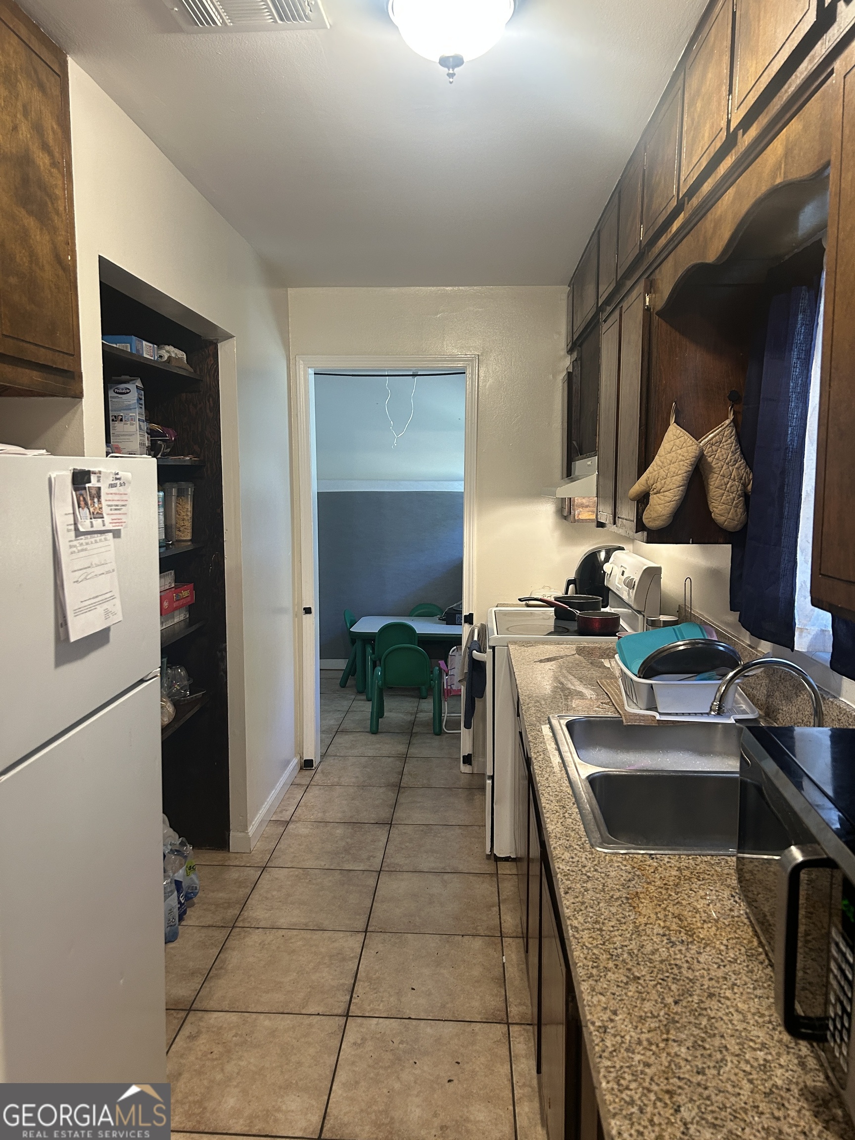 219 Oregon Trail Warner Robins, GA 31093 - Photo 5 of 8 a kitchen with a sink a stove and a refrigerator