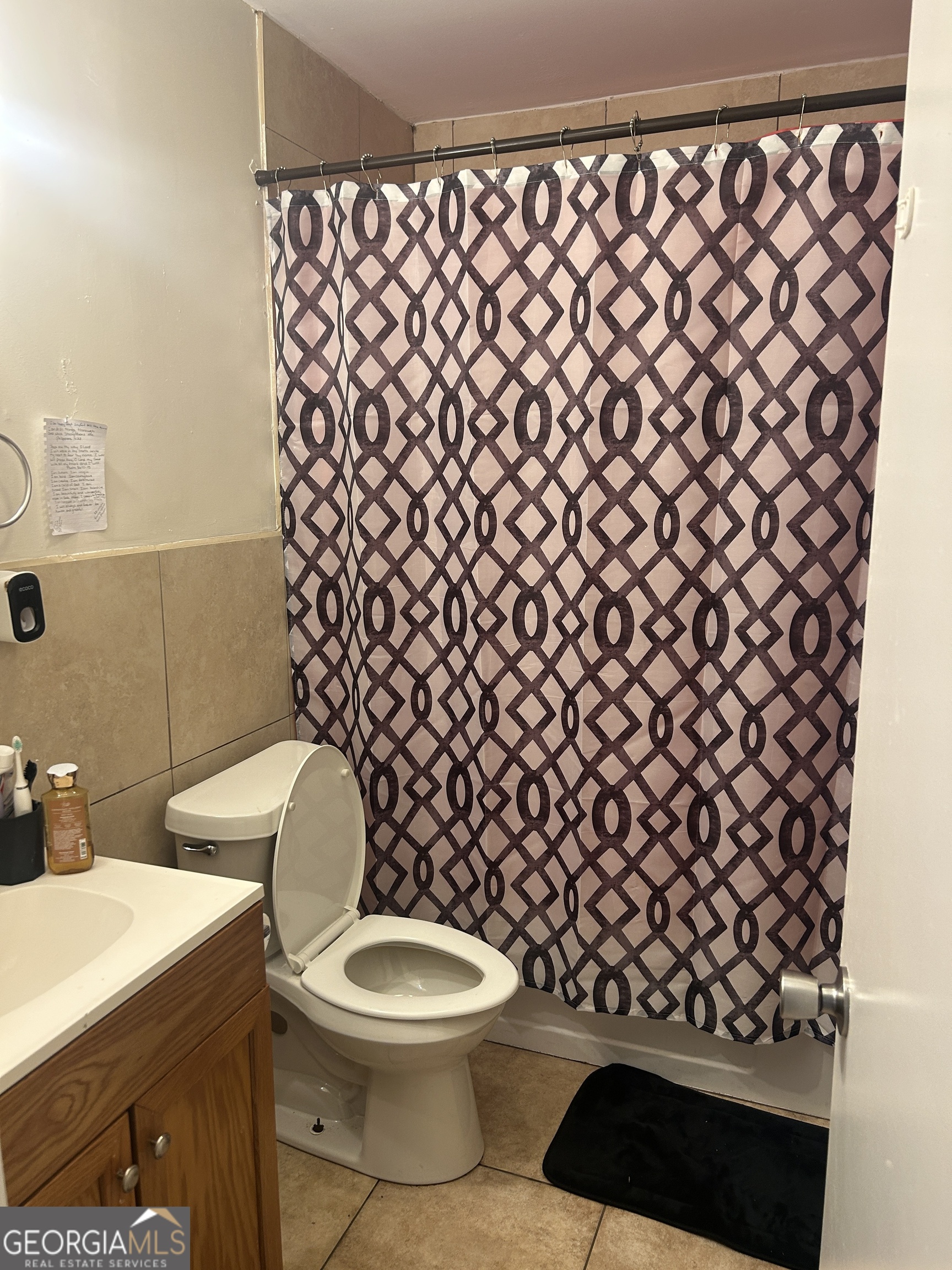 219 Oregon Trail Warner Robins, GA 31093 - Photo 6 of 8 a white toilet sitting next to a shower curtain