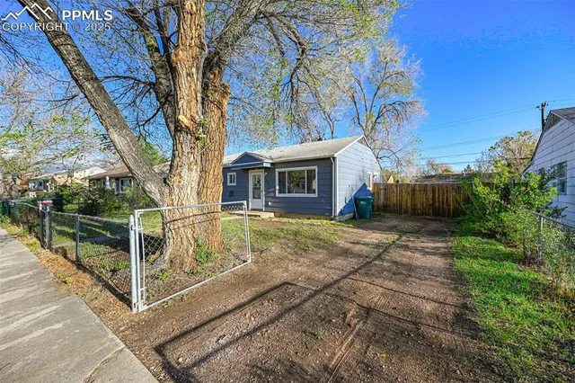 a view of a house with backyard and trees