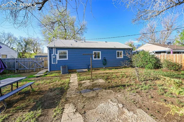 a view of a house with a yard and wooden fence