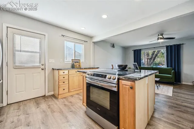 a kitchen with granite countertop a stove top oven sink and cabinets