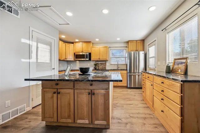 a kitchen with granite countertop a sink counter top space a refrigerator and cabinets