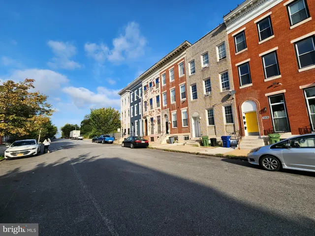 a city street lined with buildings and cars parked in front of it
