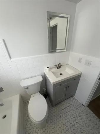 a bathroom with a toilet sink and mirror