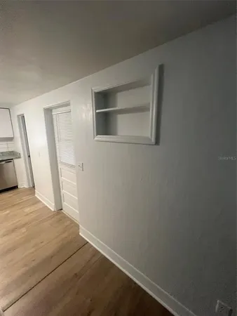 a view of empty room with wooden floor