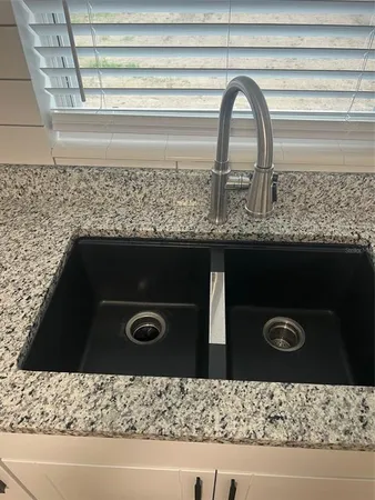 a sink has a granite top and a stove