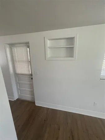 an empty room with wooden floor and cabinet
