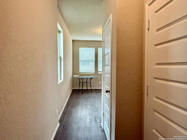a view of a hallway with wooden floor and a window