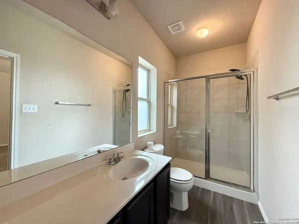 a bathroom with a double vanity sink toilet and shower