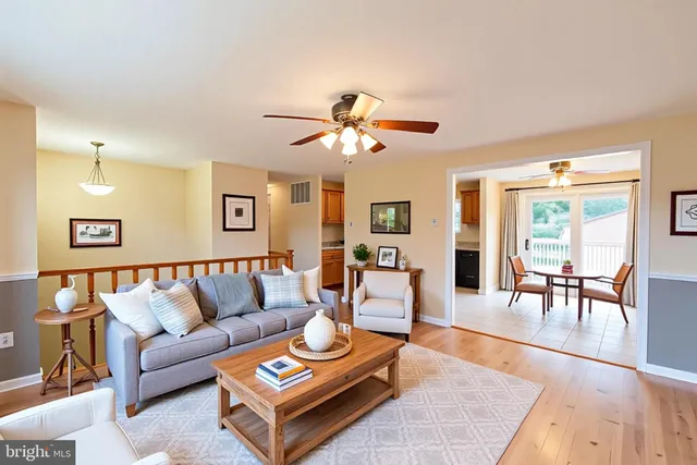 a living room with furniture and a dining table with wooden floor
