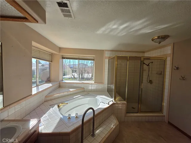 a spacious bedroom with a bed and glass door