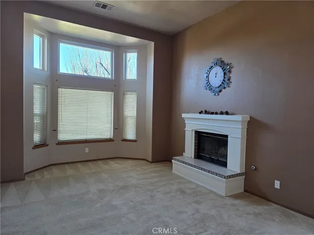 a view of an empty room with a fireplace and a window