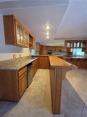 a kitchen with stainless steel appliances granite countertop a sink stove and cabinets