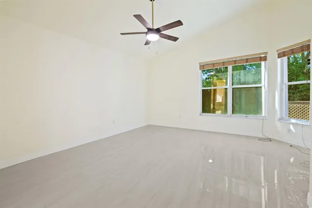 an empty room with a window and a ceiling fan