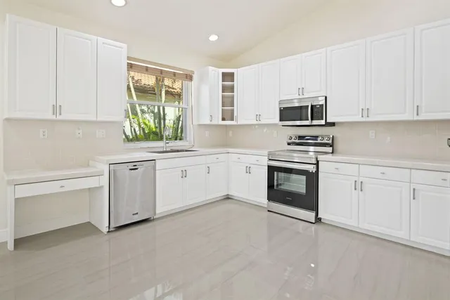 a kitchen with white cabinets stainless steel appliances and sink