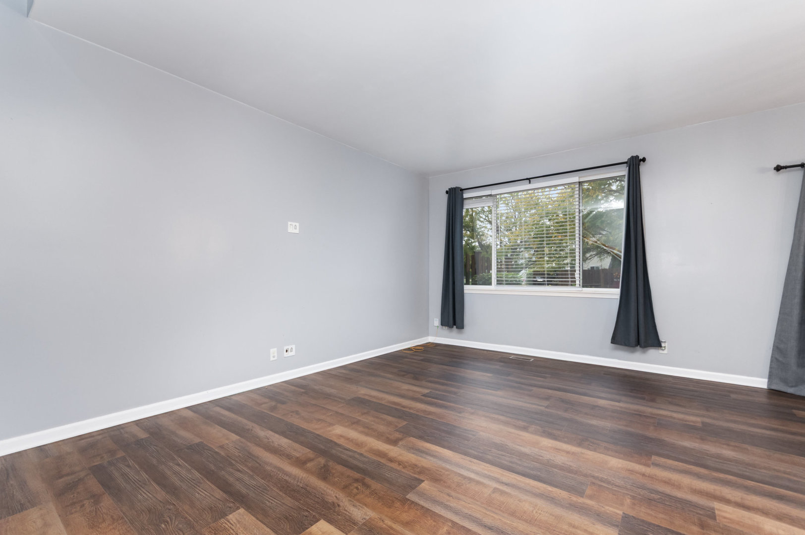 1796 South Wentworth Circle Romeoville, IL 60446 - Photo 6 of 21 a view of an empty room with wooden floor and a window
