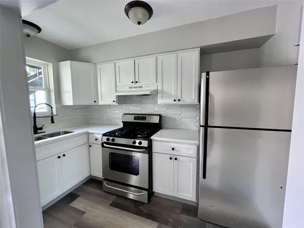 a kitchen with a refrigerator sink and cabinets