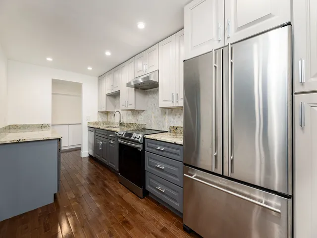 a kitchen with granite countertop a sink stove and cabinets