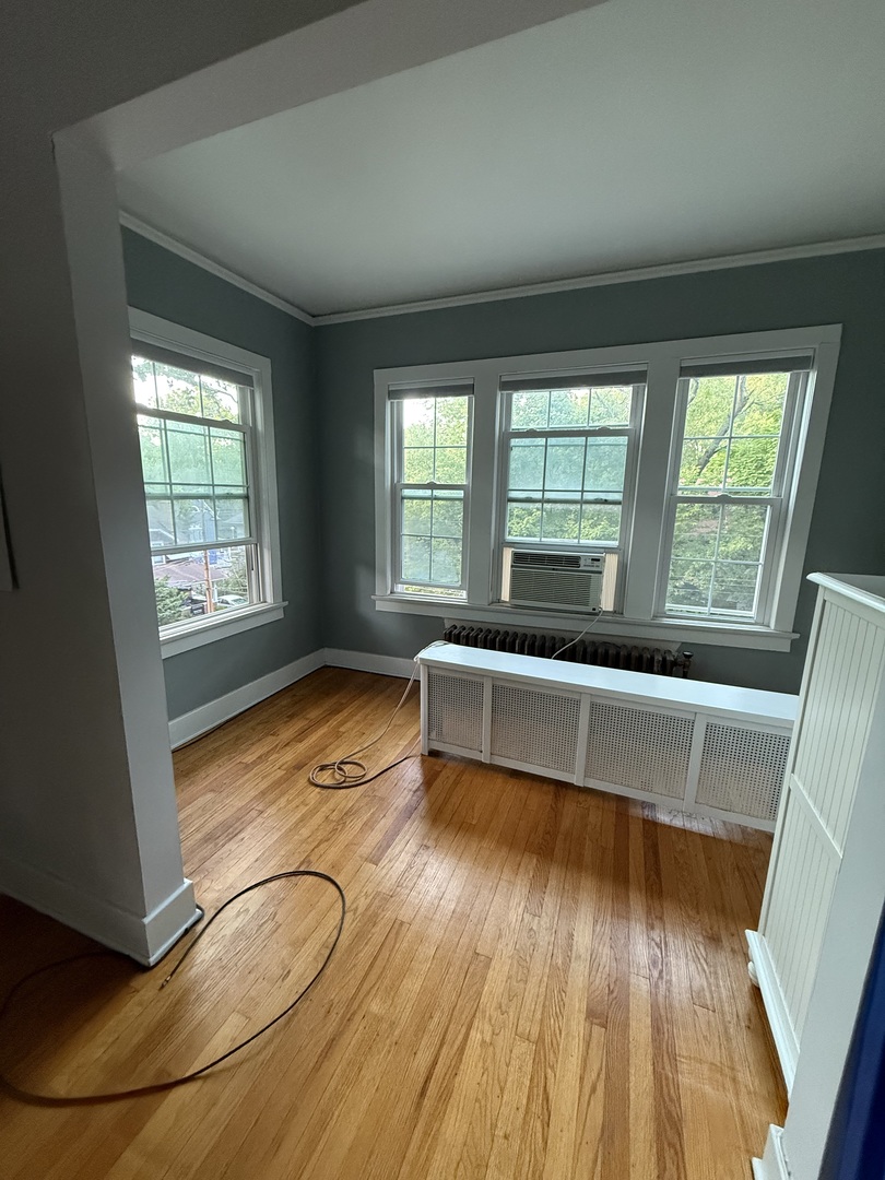 706 South Coler Avenue, Unit 5 Urbana, IL 61801 - Photo 11 of 21 a view of an empty room with wooden floor and a window