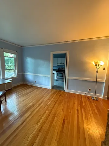 a room with a bed and lots of wooden floor