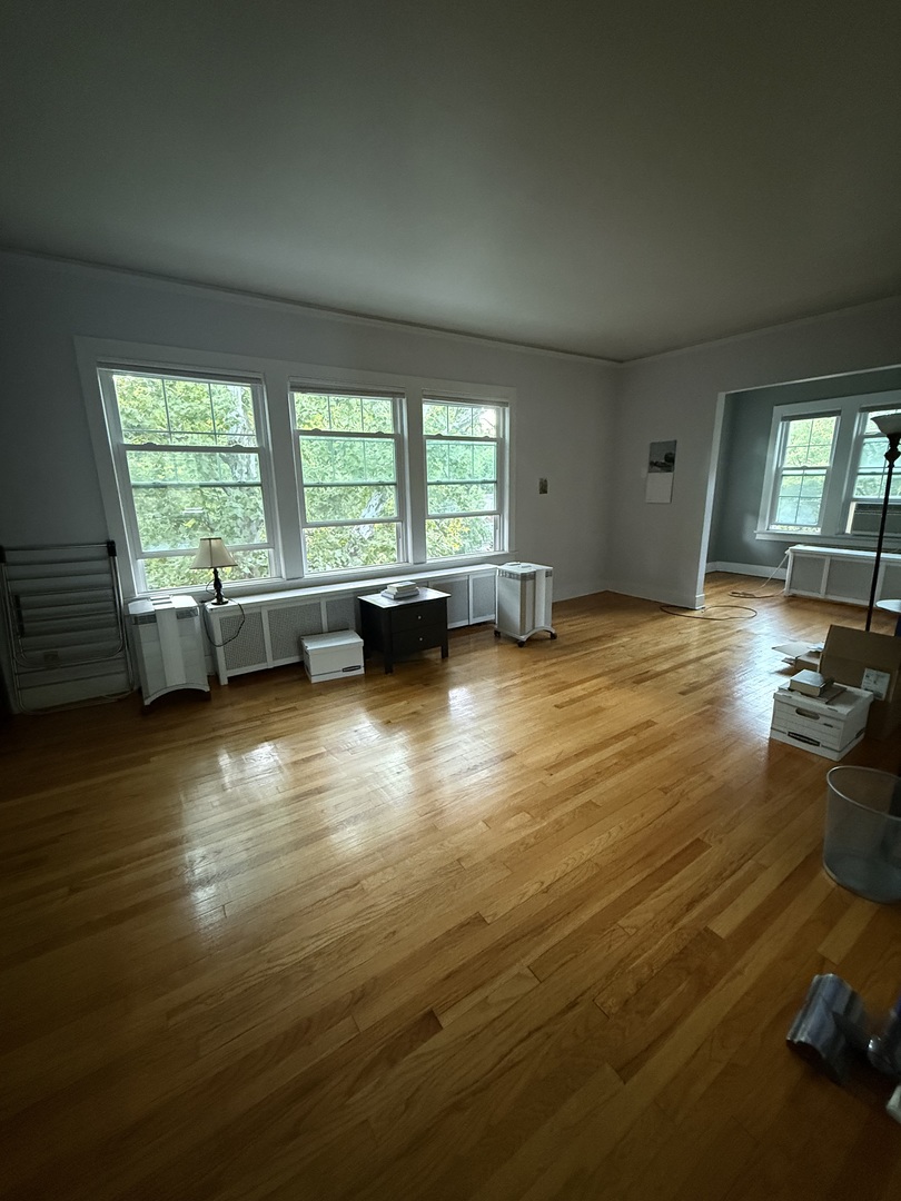 706 South Coler Avenue, Unit 5 Urbana, IL 61801 - Photo 10 of 21 an empty room with floor to ceiling window and wooden floor