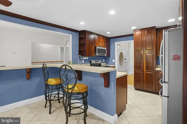 a kitchen with stainless steel appliances granite countertop a refrigerator a sink a stove a microwave and island