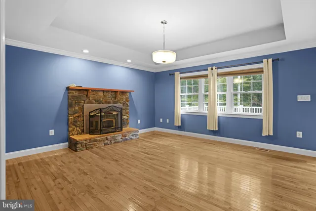 a view of an empty room with a fireplace and a window