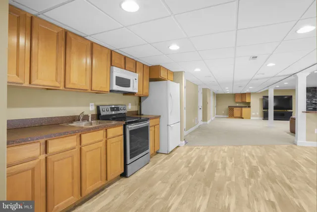 a kitchen with granite countertop a sink cabinets stainless steel appliances and a window