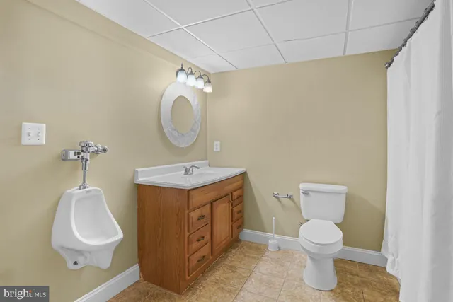 a bathroom with a toilet sink and mirror