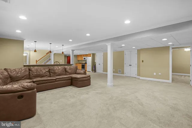 a living room with furniture and a refrigerator