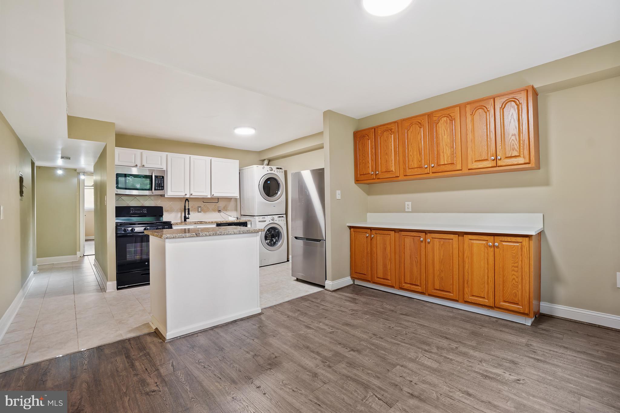 8487 Greenbelt Road Greenbelt, MD 20770 - Photo 9 of 29 a kitchen with refrigerator cabinets and wooden floor