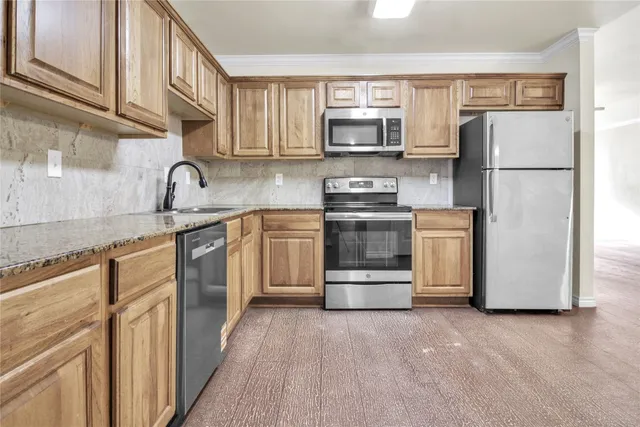 a kitchen with stainless steel appliances granite countertop a refrigerator stove a sink and a microwave