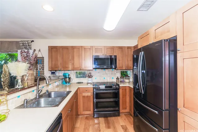 a kitchen with stainless steel appliances granite countertop a refrigerator stove and sink