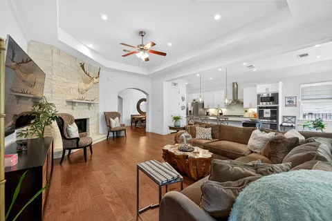a living room with furniture kitchen view and a chandelier