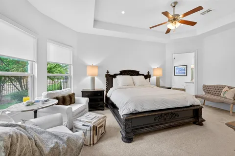a bedroom with a bed a couch and a large window