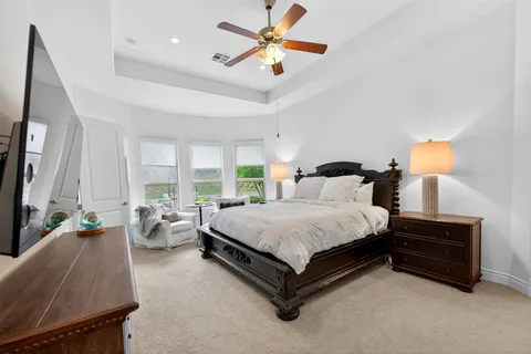 a spacious bedroom with a bed and a chandelier