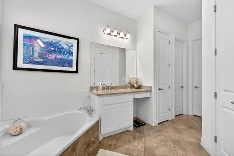 a bathroom with a tub a sink and a mirror