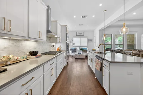 a kitchen with counter top space a sink appliances and cabinets