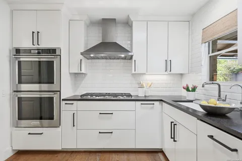 a kitchen with stainless steel appliances granite countertop a sink stove and cabinets